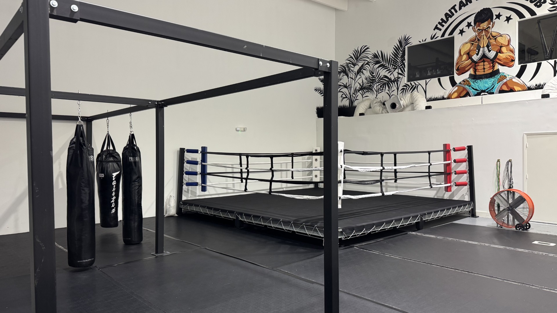 Boxing ring and heavy bags inside Thaitan Boxing Club